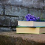 A stack of two books with a cutting of lavender resting on top