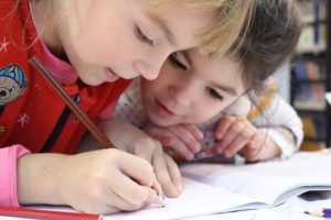 Two young girls coloring together